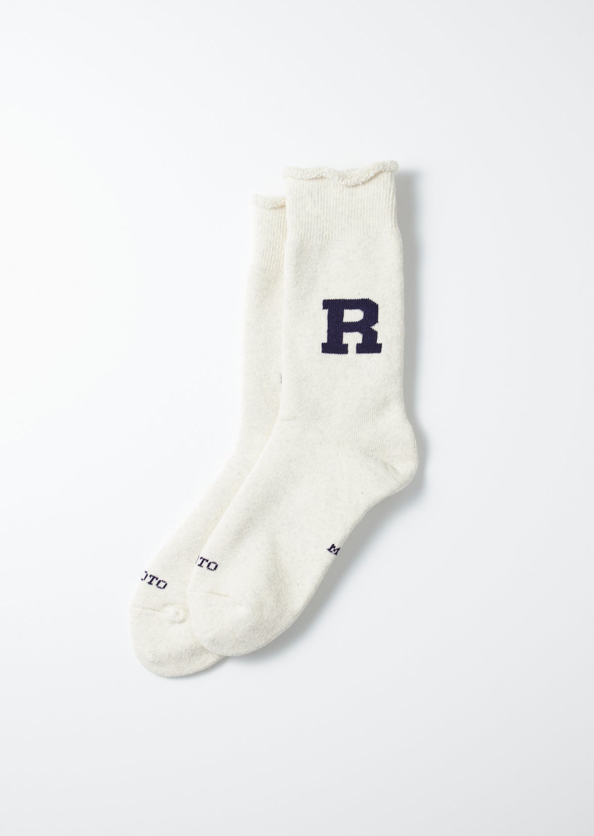Cream off-white sweat socks with a large navy R logo and ruffled cuffs, lying flat.