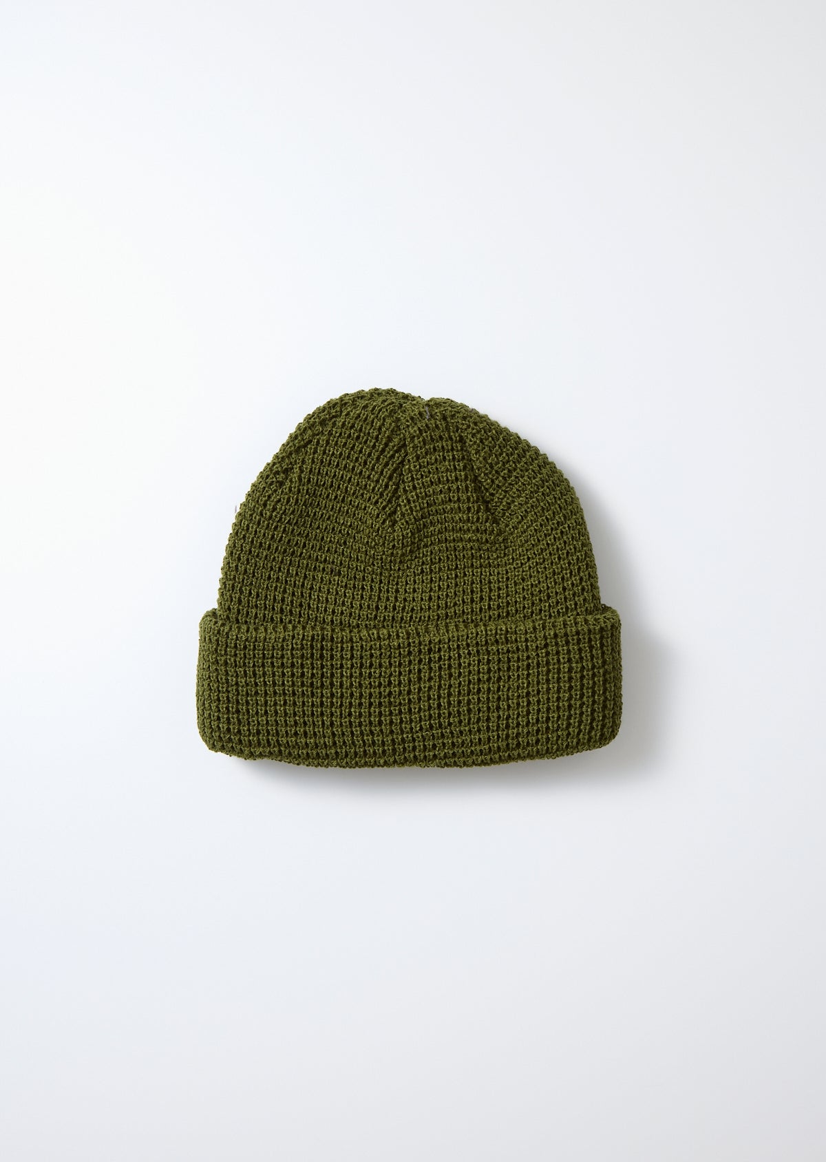 Dark olive green waffle knit watch cap with a ribbed cuff, flat lay.