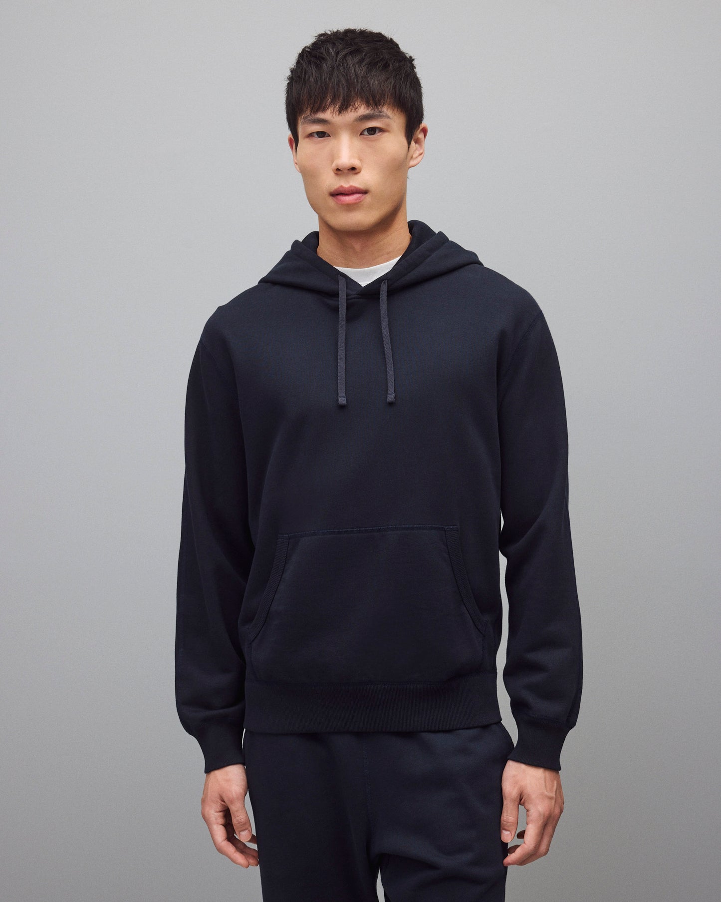 Navy blue Midweight Terry Standard Hoodie with drawstrings and a front pouch pocket, worn by a male model.