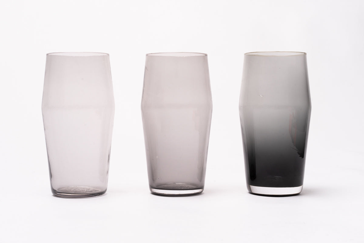 B grade 20 oz pint glasses in varying translucent grey shades, displayed on a white background.