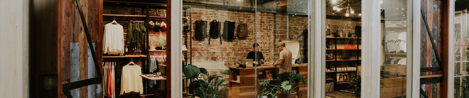 Rustic brick shop with wooden shelves, earth-toned apparel, and backpacks—urban wanderer essentials in warm, natural tones.