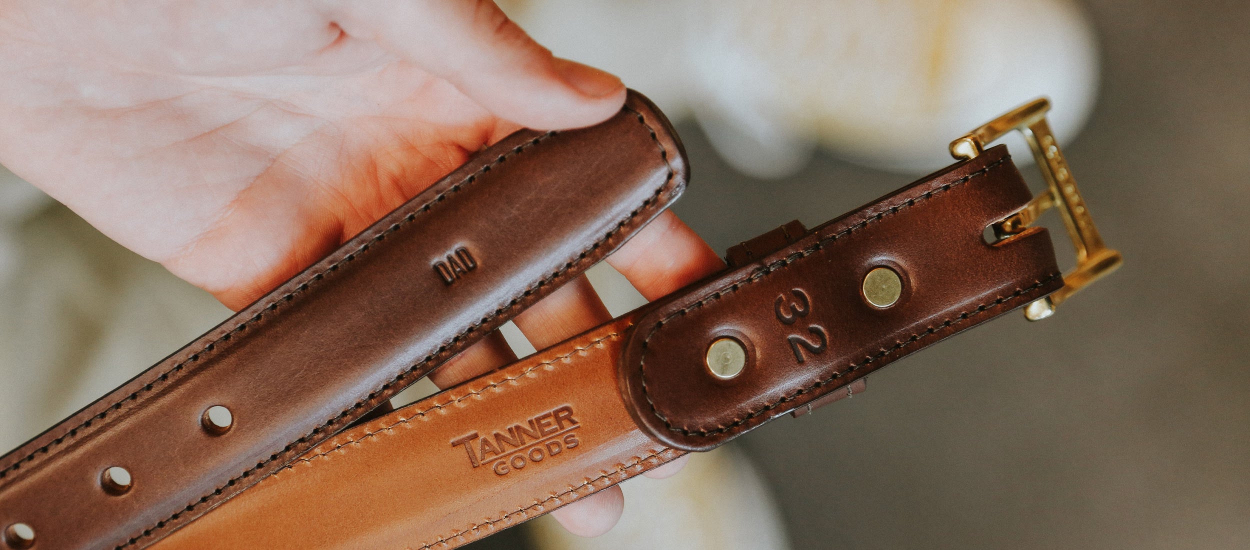 Rich brown leather dress belts with gold hardware, personalized engravings, and precise stitching for timeless elegance.
