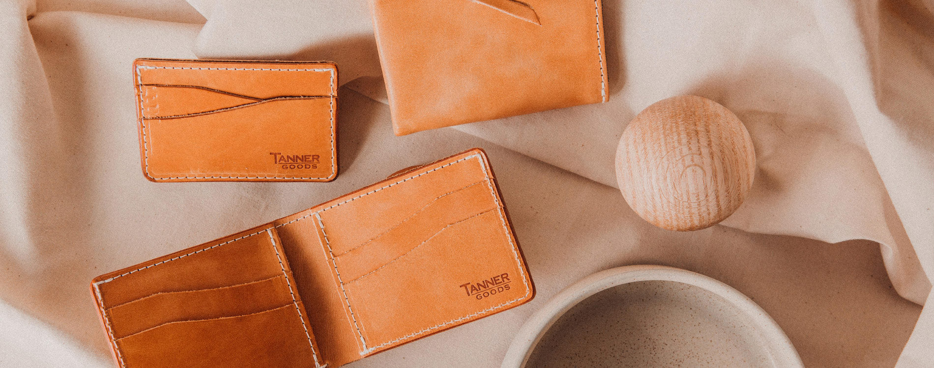 tan leather wallets on a beige background