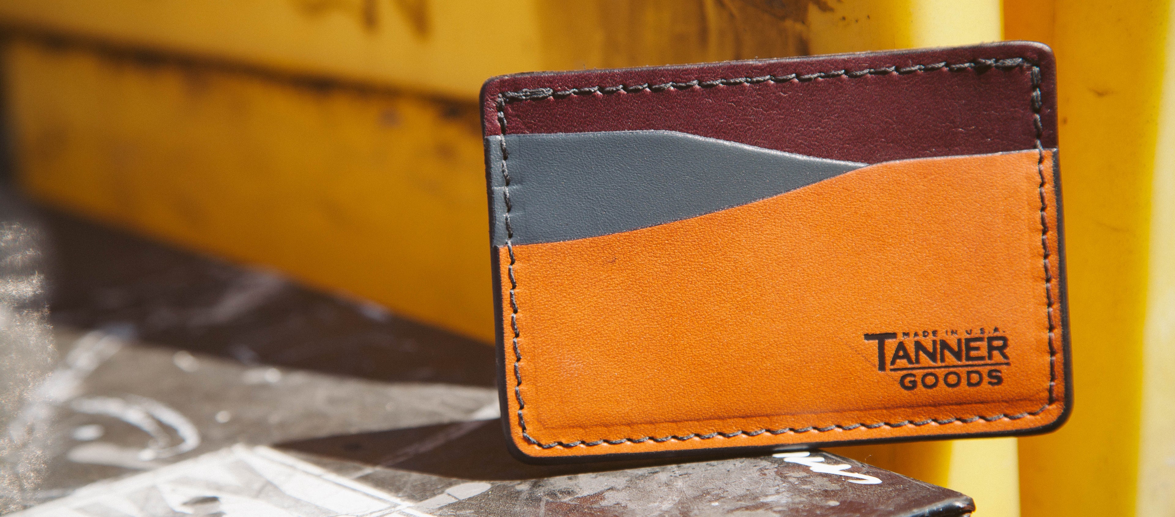 Bold leather cardholder in burgundy, gray, and orange, hand-stitched, urban street style, Tanner Goods, made in USA.