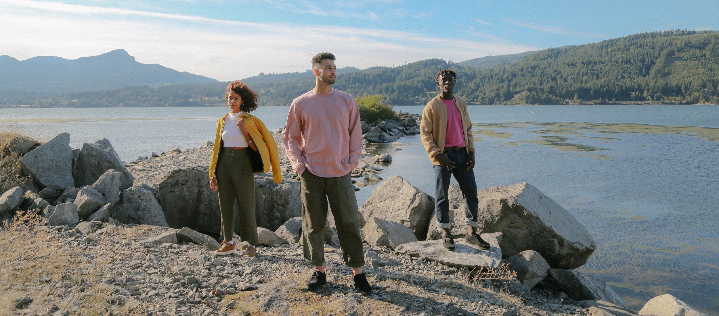 Three people wearing nice clothes standing on the banks of the Columbia River.