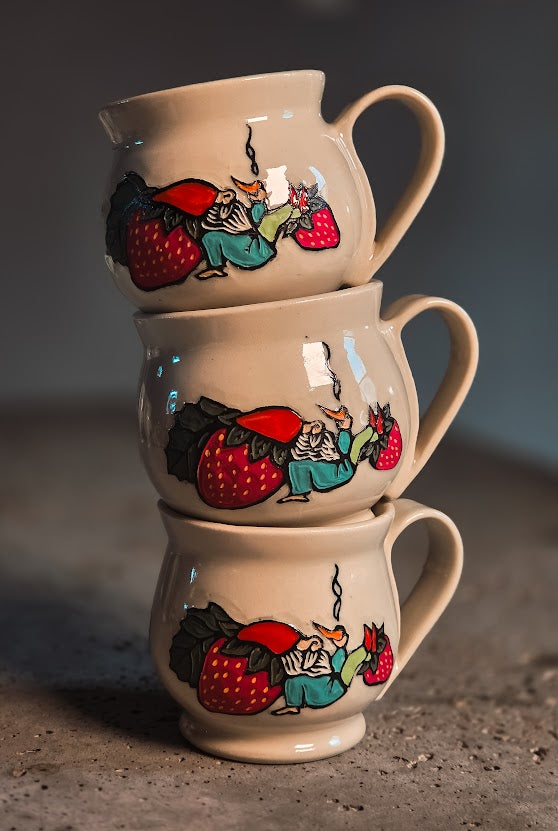 Three stacked beige ceramic gnome espresso mugs, each with a hand-painted gnome and red strawberries.