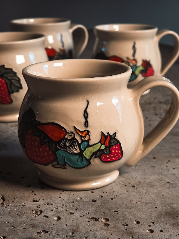 Off-white ceramic gnome espresso mug with a colorful hand-painted design of a gnome and strawberries.
