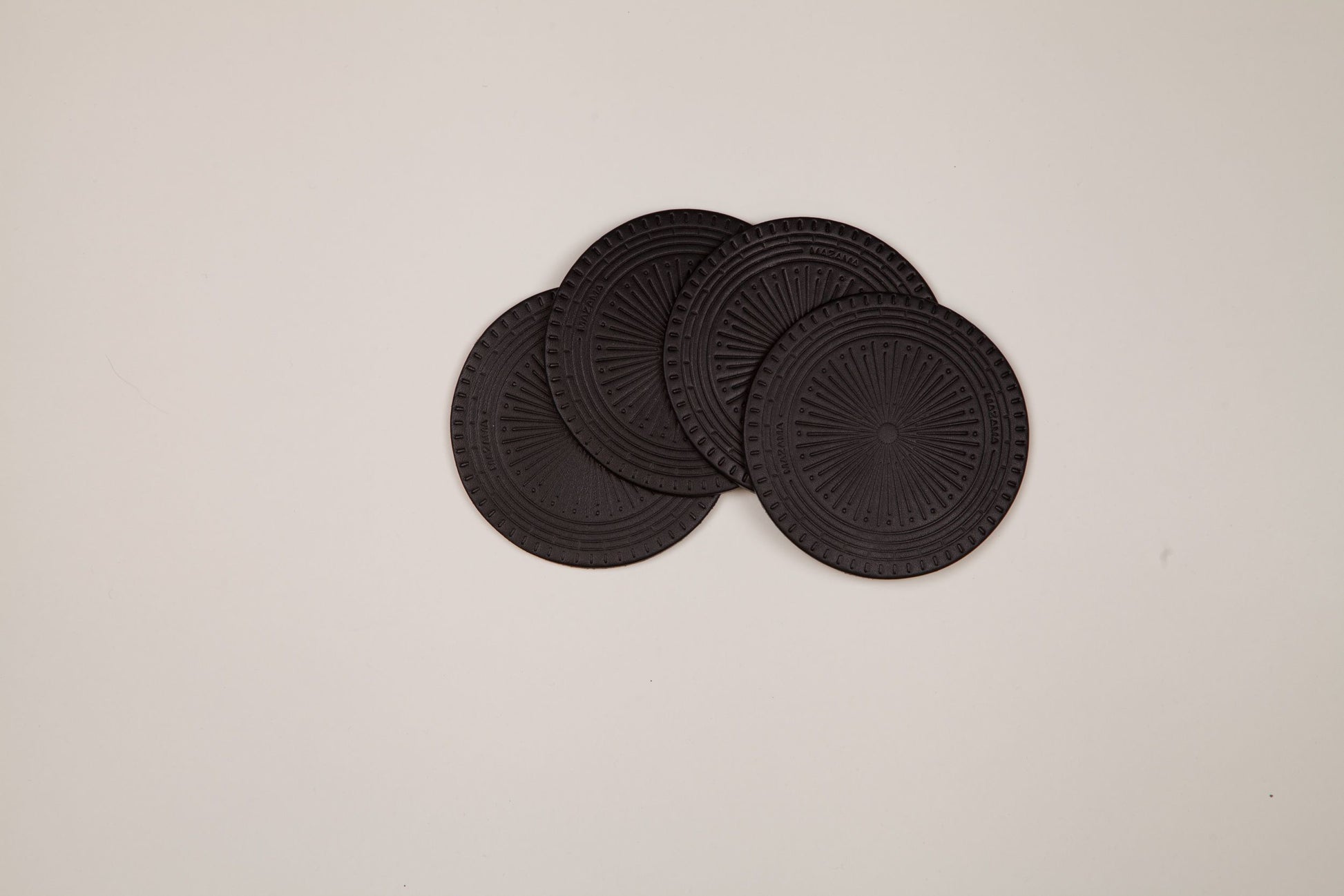 Dark grey textured Coaster Set of 4 with a radial pattern and 'MAZAMA' text, partially overlapping.