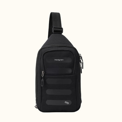 Black fabric sling bag by Hedgren, front view, with horizontal front panels, a unique lower symbol, and an adjustable strap.