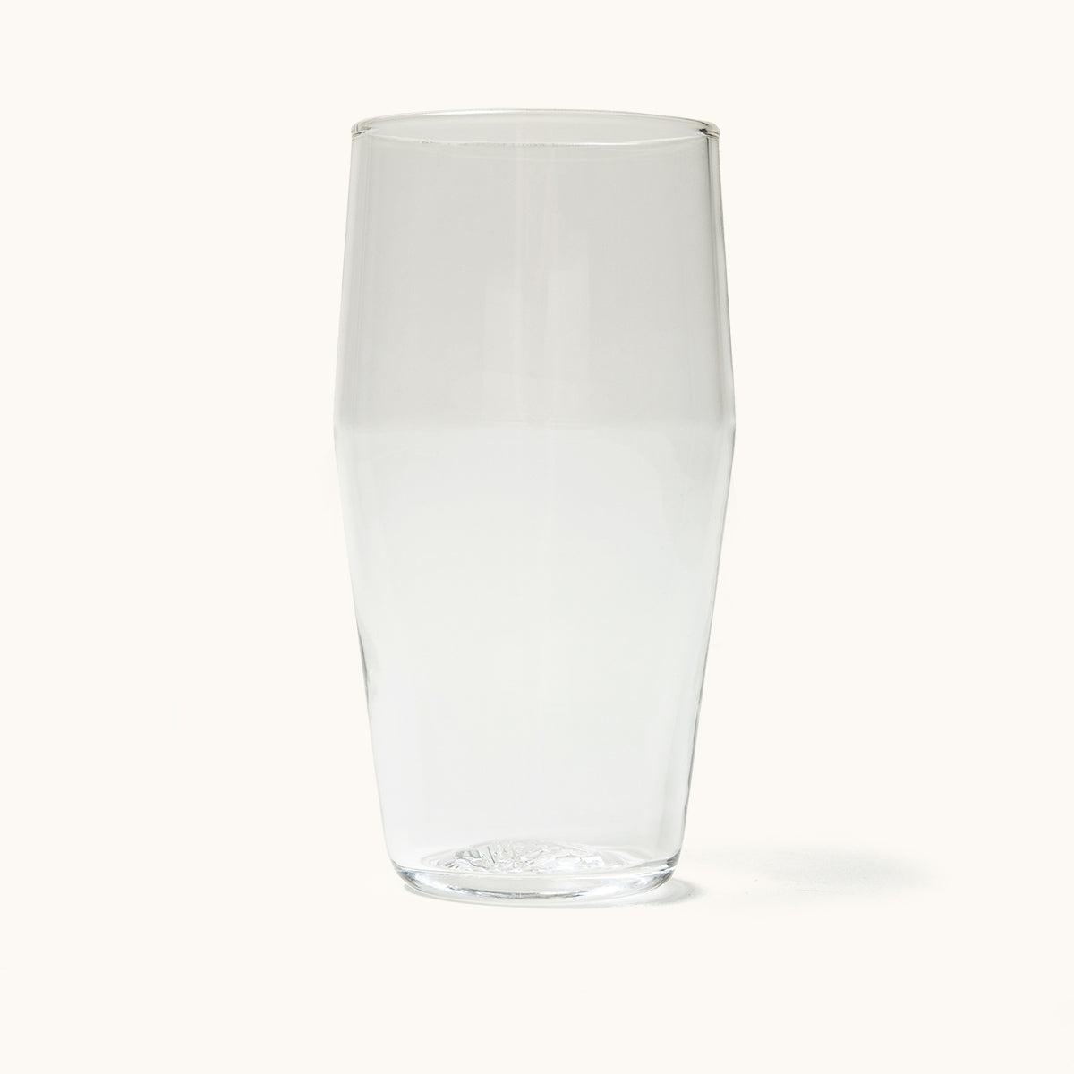 Clear standard pint glass with tapered shape and textured base, front view on white background