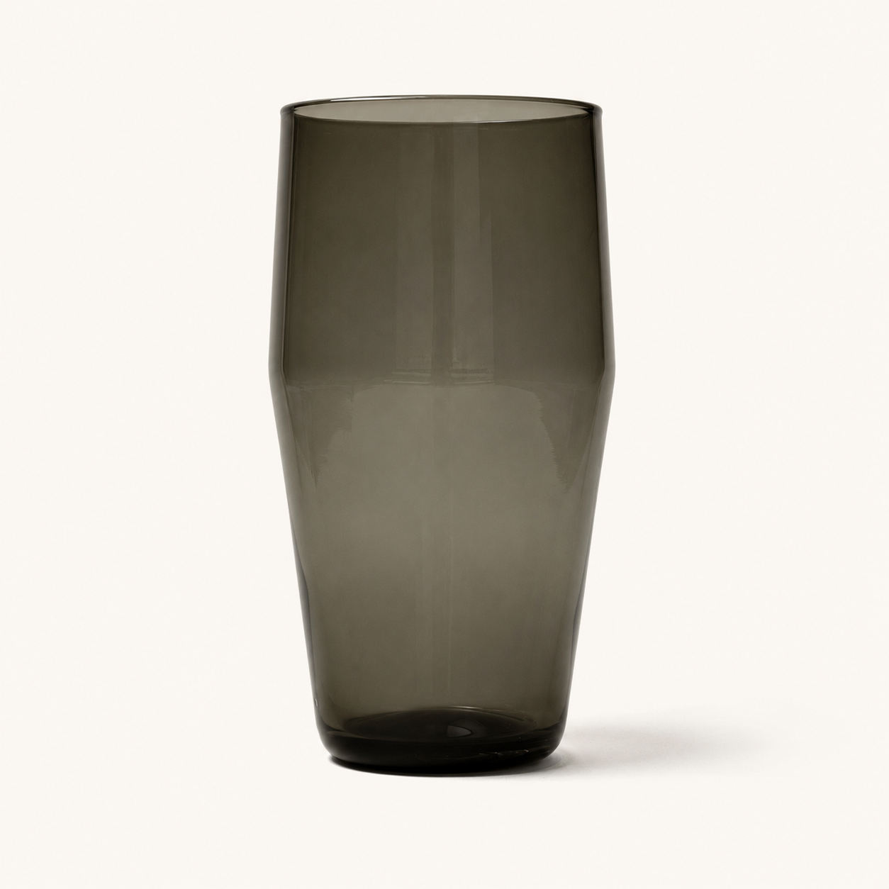 Smoky gray tinted pint glass with faceted sides and rounded base, front view on white background