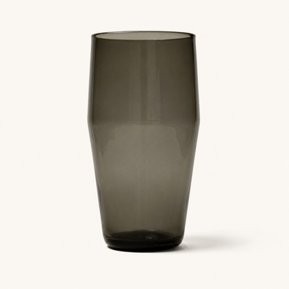 Smoky gray tinted pint glass with faceted sides and rounded base, front view on white background