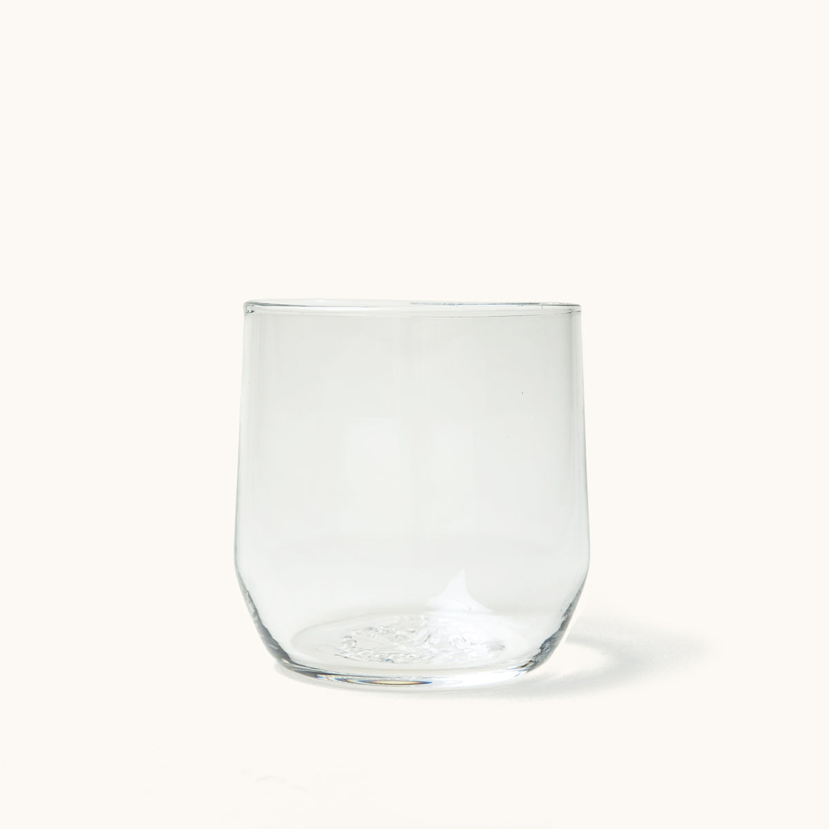 Clear glass cocktail glass with a stemless design, rounded bottom, and slight taper.