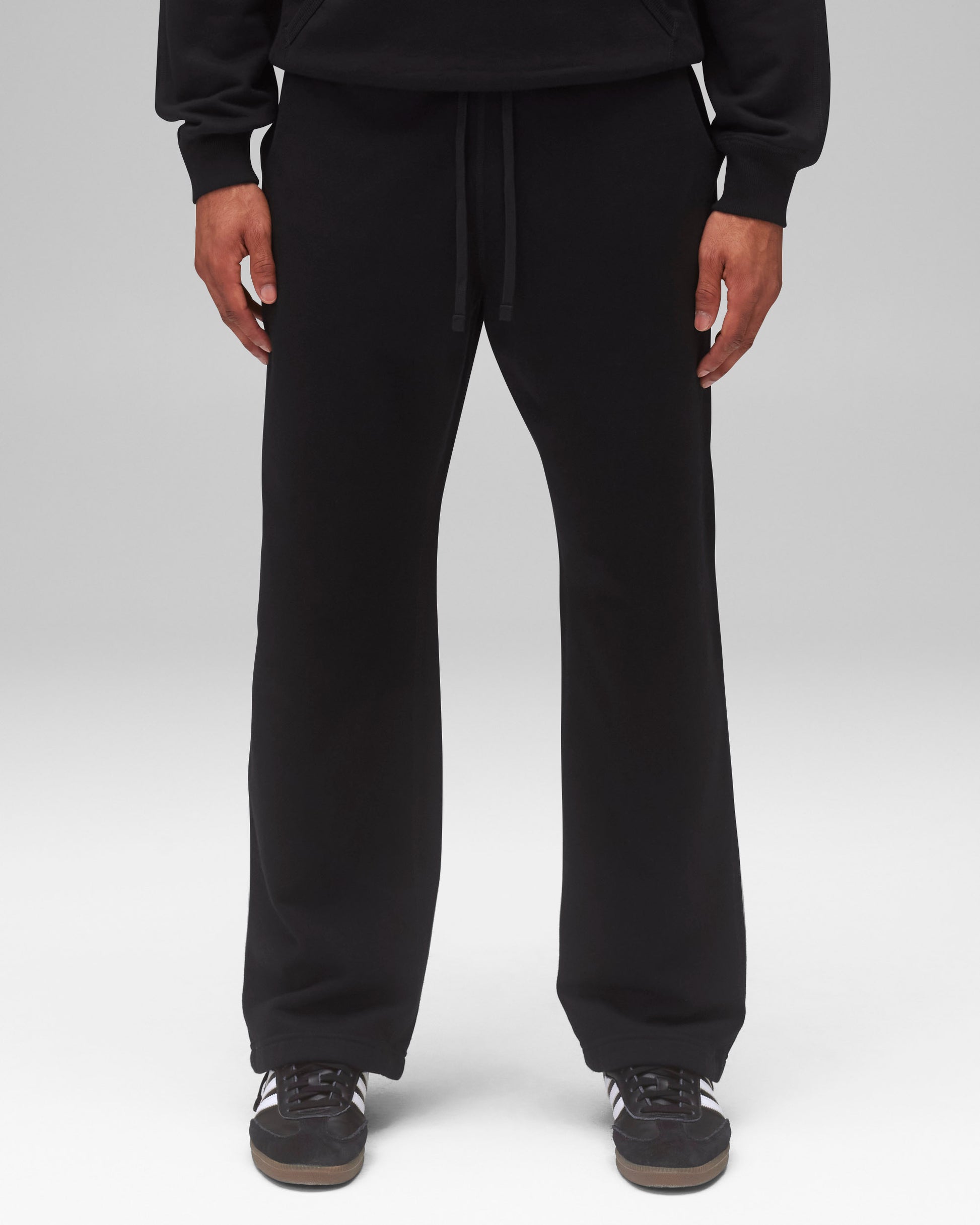 Black Midweight Terry Relaxed Sweatpants with a drawstring, worn with a black hoodie and sneakers.