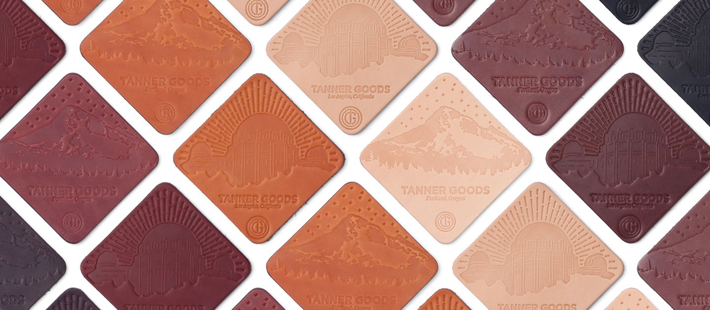 Varied earth-toned leather coaster set of 4 by TANNER GOODS with embossed mountain and observatory designs.