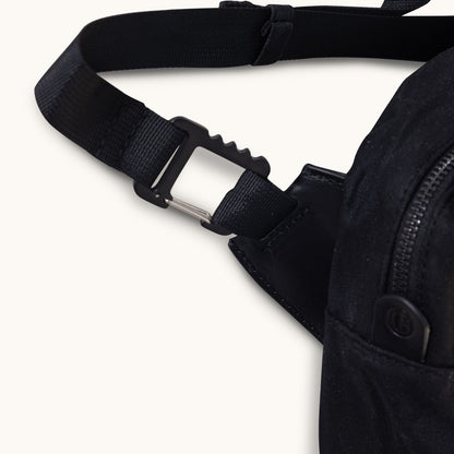 Cropped black waxed canvas Canyon Crossbody Large showing a textured strap and a black carabiner clasp.