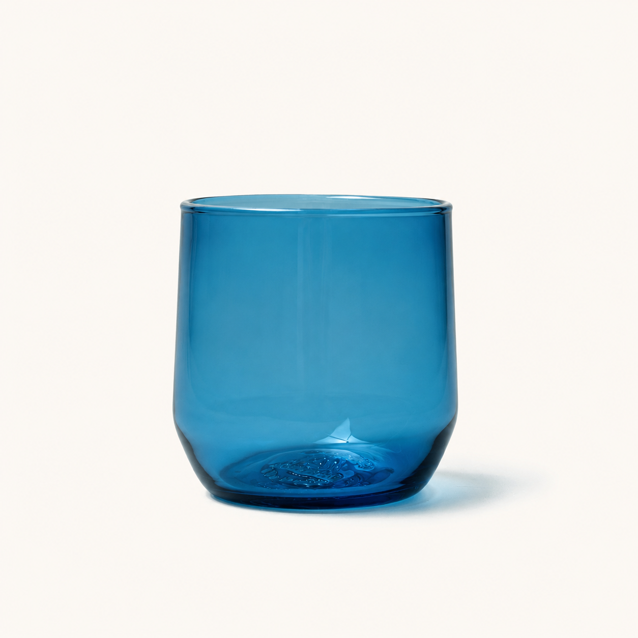 Vibrant blue cocktail glass with textured base, front view, smooth glass finish, rounded shape
