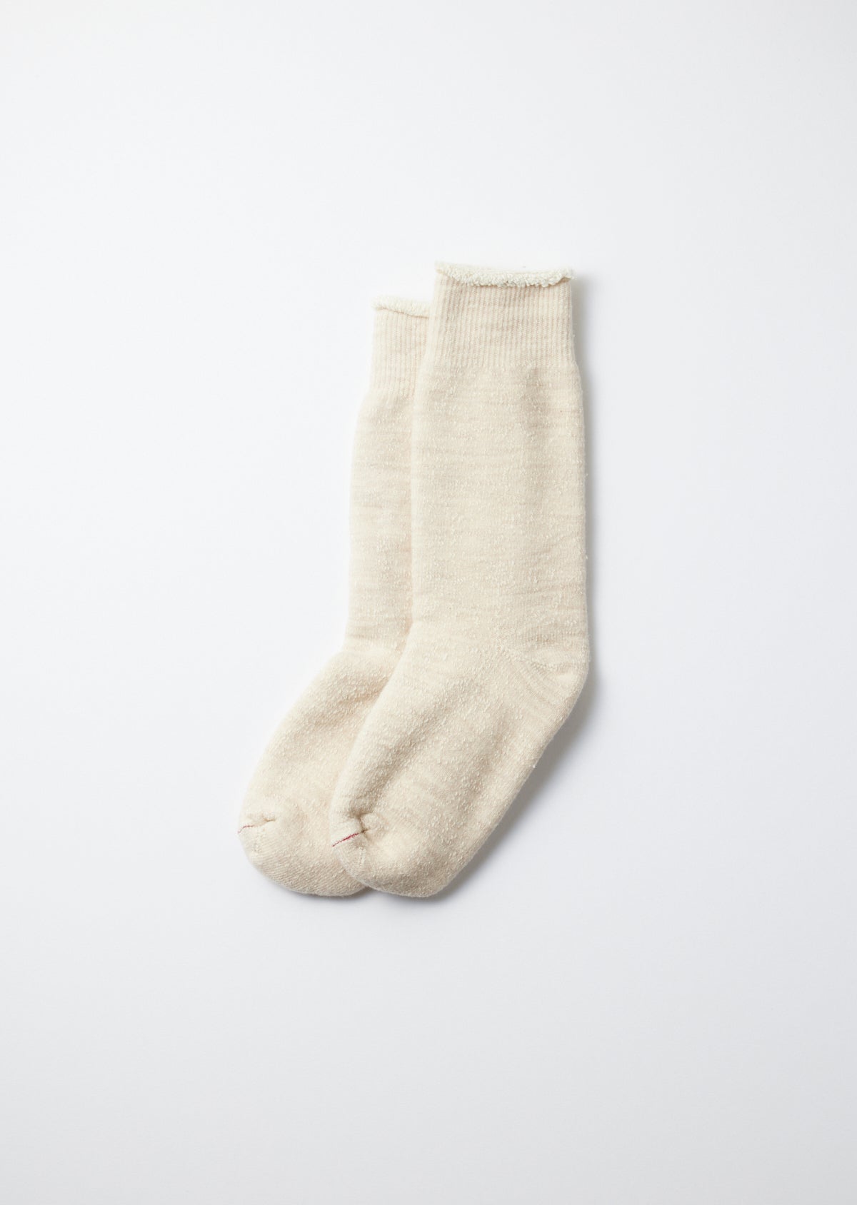 Off-white double face crew socks with ribbed cuffs, fuzzy texture, and small red stitches on the toes.