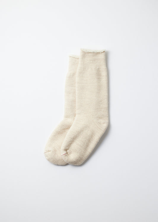 Off-white double face crew socks with ribbed cuffs, fuzzy texture, and small red stitches on the toes.