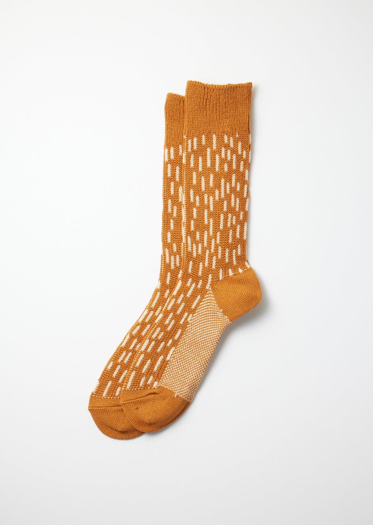 Pair of mustard yellow crew socks with an off-white dash pattern and a mesh knit foot detail.