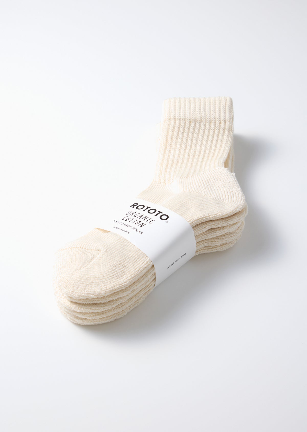 Three-pack of off-white organic cotton mini crew socks by ROTOTO, neatly stacked with a white label band.