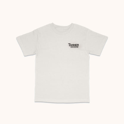 White short-sleeved T-shirt with a small black "Tanner Goods" logo on the left chest, laid flat.