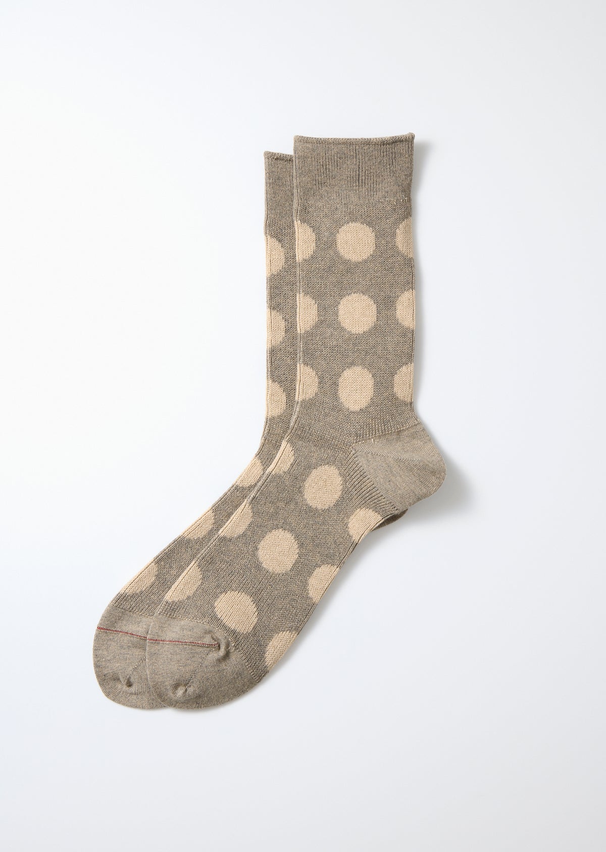 Gray and beige Porthole Dot knit socks laid flat on a white background.
