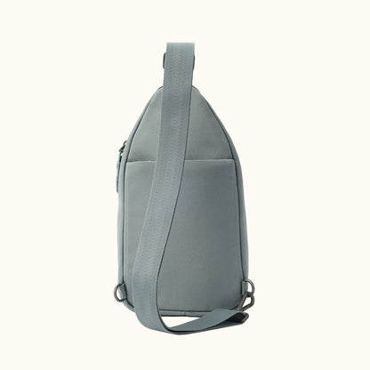 Dusty teal sling bag by Hedgren, side view, with an adjustable strap and visible hardware.