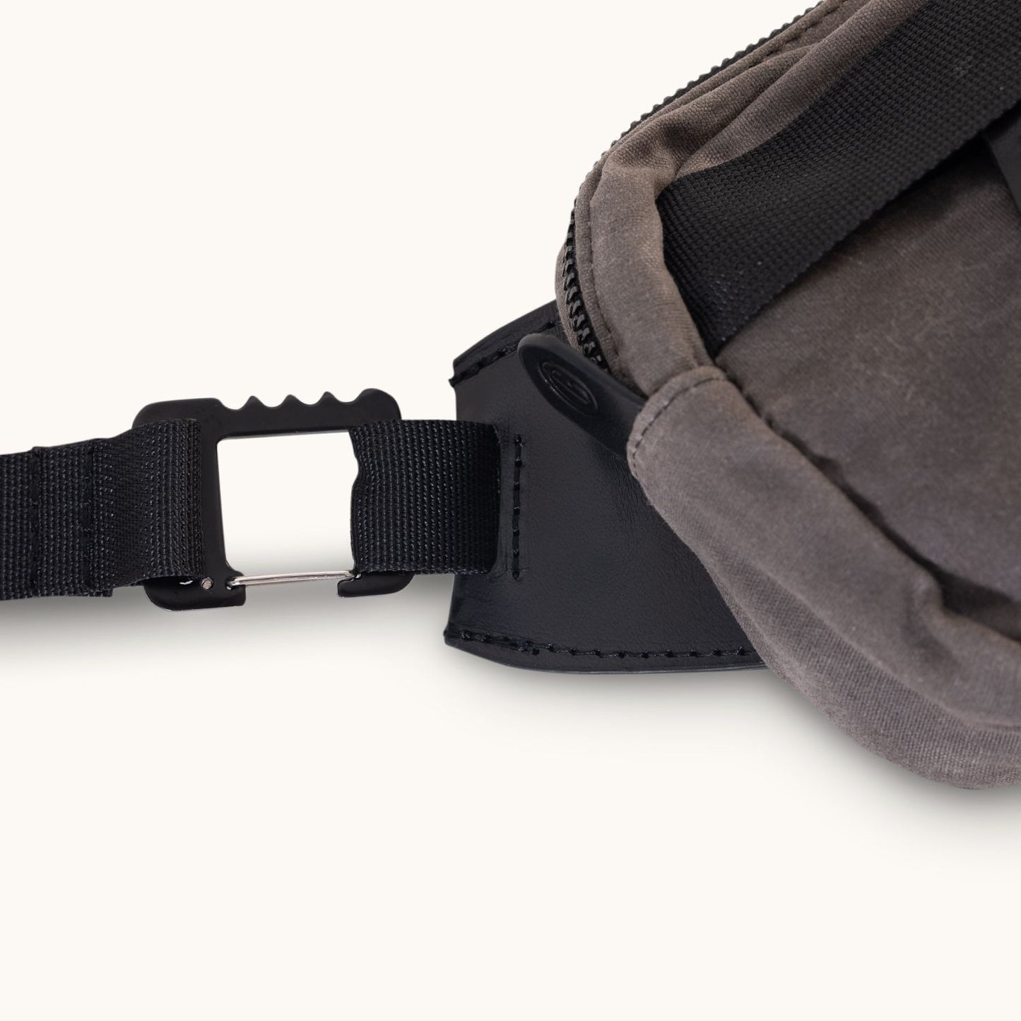 Slate grey waxed canvas Canyon Crossbody Mini bag, showing a black strap connecting to a silver metal hook-and-pin buckle, cropped.