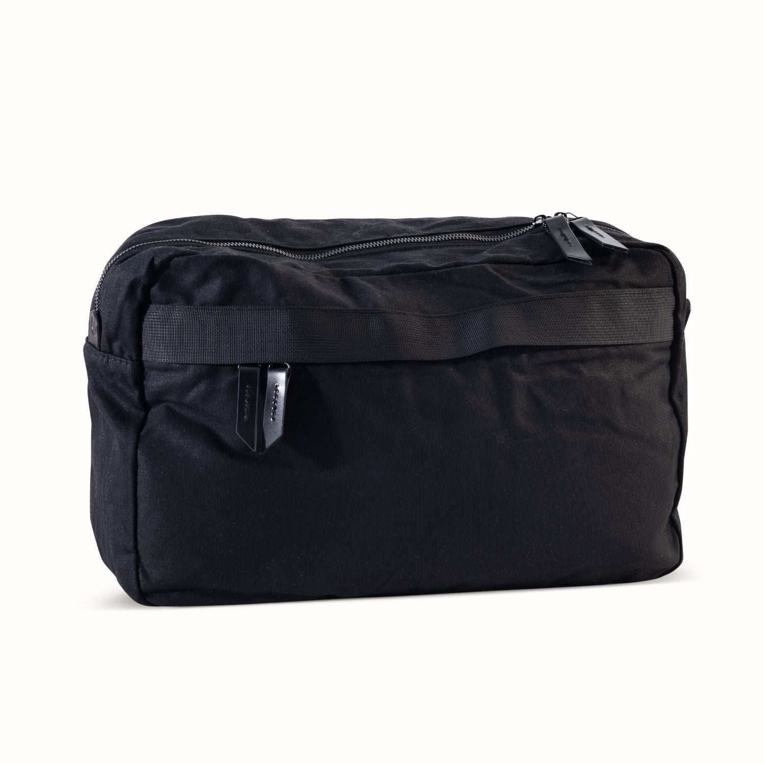 Large black waxed canvas crossbody bag featuring a main zipper and a horizontal front webbing strap.