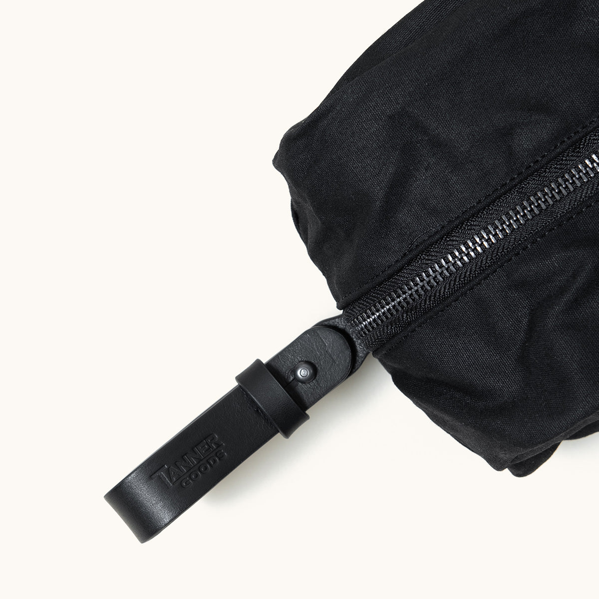 Onyx waxed canvas Dopp Kit by Tanner Goods, with a black zipper and branded leather pull.