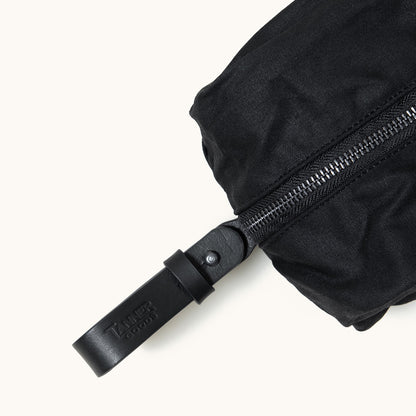 Onyx waxed canvas Dopp Kit by Tanner Goods, with a black zipper and branded leather pull.