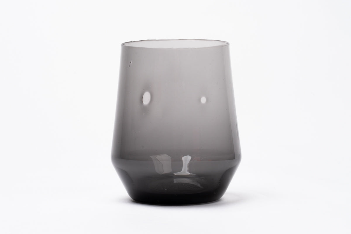Smoky dark gray glass wine glass with a conical shape, wider top, and thick base.