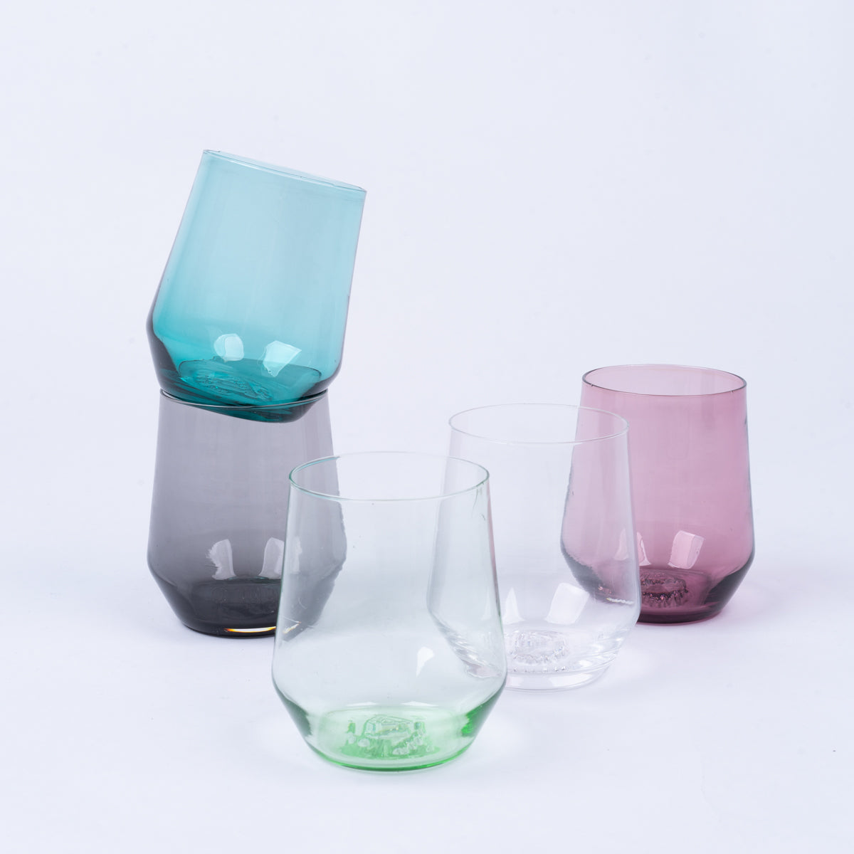 Assorted stemless wine glasses in various colors: teal, grey, green, clear, and pink.