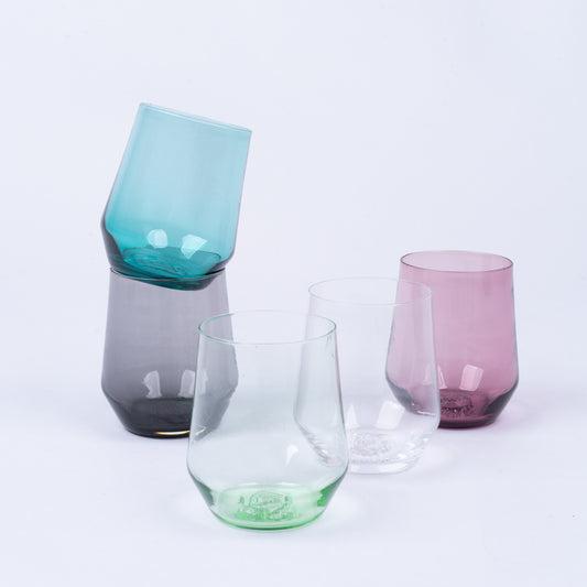 Assorted stemless wine glasses in various colors: teal, grey, green, clear, and pink.