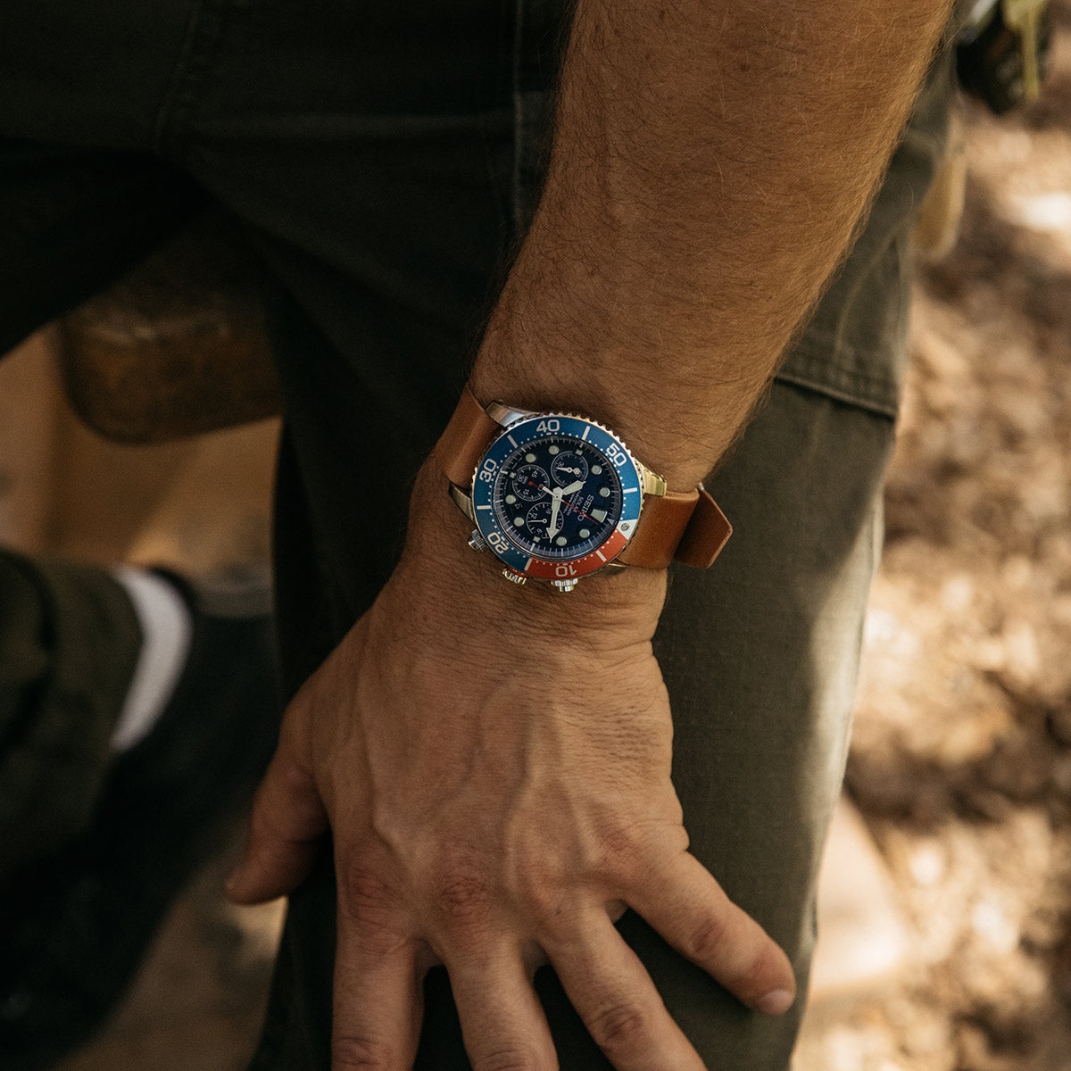 Cordovan leather Nato watch strap in natural color by, worn on wrist with blue dial watch, side view, textured surface, lifestyle shot