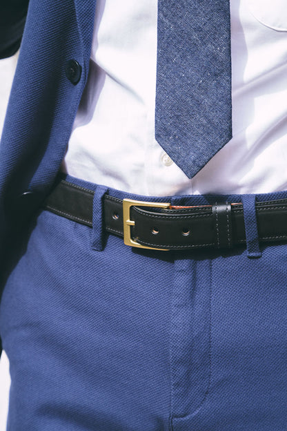 Black dress belt with a gold buckle, styled with a blue suit, white shirt, and blue tie.