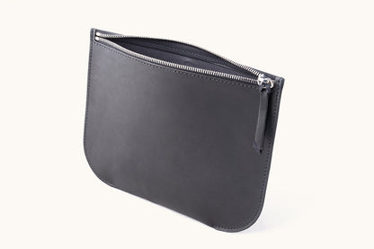 Dark gray universal zip pouch with a smooth finish, featuring a slightly open silver zipper and rounded corners.