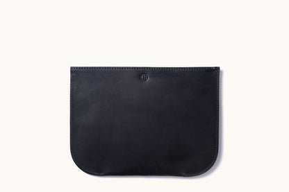 Black leather zip pouch with a debossed circular logo, stitched edges, and rounded bottom corners, laid flat.