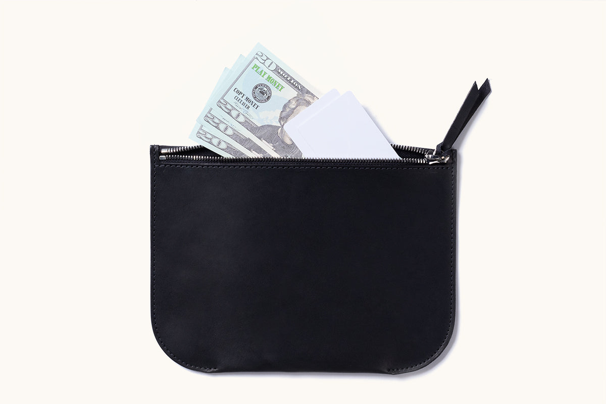 Black rectangular Universal Zip Pouch with rounded corners, unzipped to reveal light blue play money and white cards.