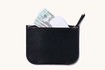 Black rectangular Universal Zip Pouch with rounded corners, unzipped to reveal light blue play money and white cards.