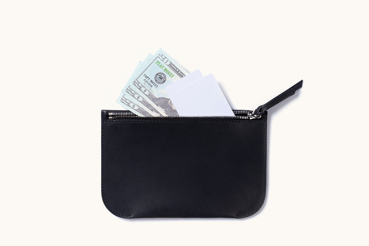 Smooth black zip pouch with an open zipper revealing play money and white cards.