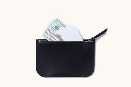 Smooth black zip pouch with an open zipper revealing play money and white cards.