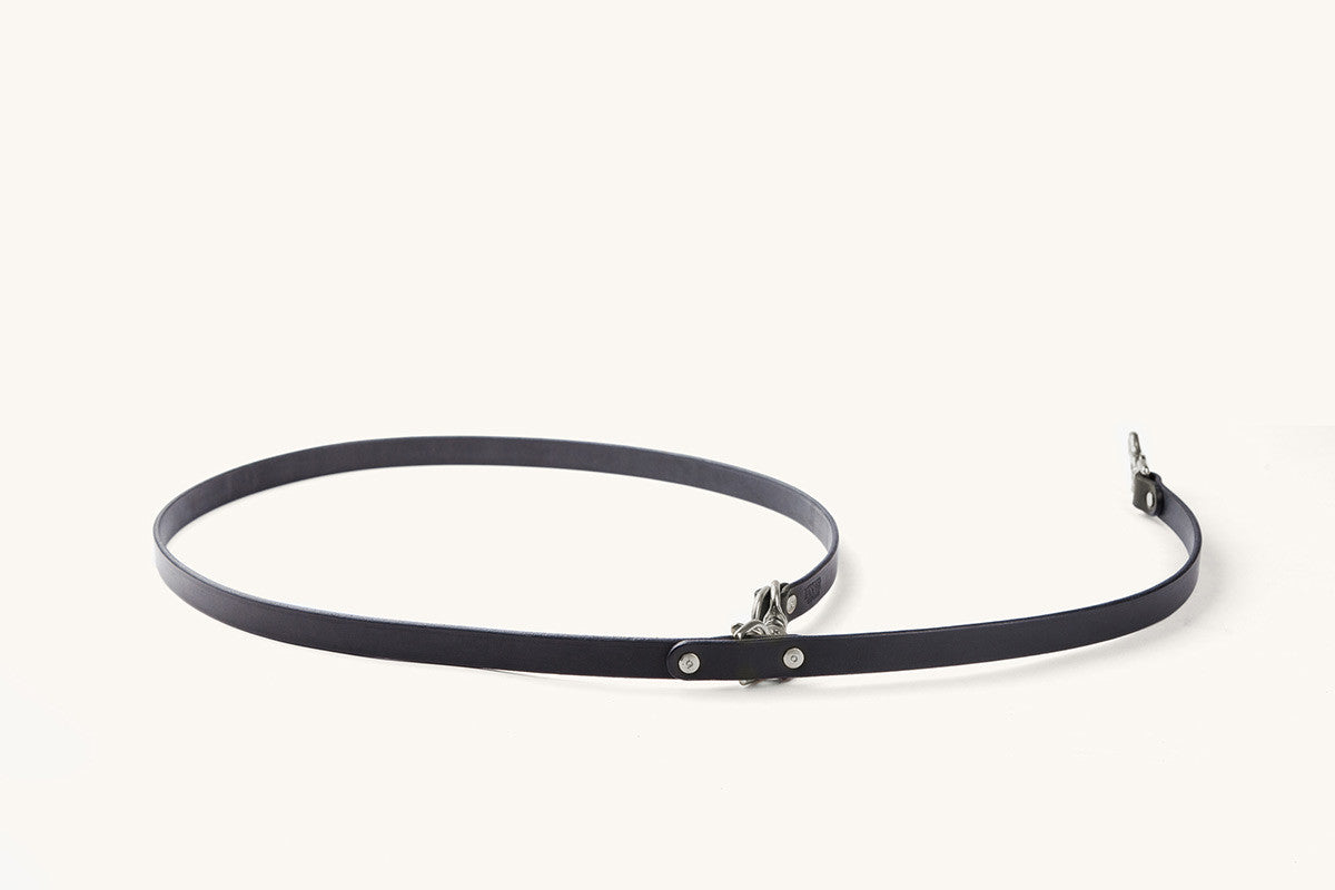 Black convertible canine lead with silver-toned hardware, laid in a loose loop on a white background.