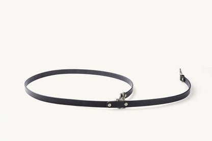 Black convertible canine lead with silver-toned hardware, laid in a loose loop on a white background.