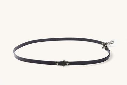 Black convertible canine lead with silver-tone metal hardware, featuring rivets and a swivel snap hook, arranged in an oval.