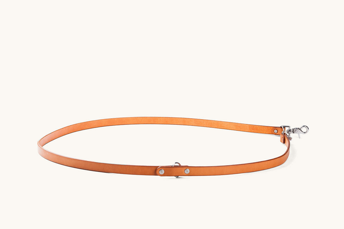 Saddle tan leather convertible canine lead looped with silver-tone metal hardware.