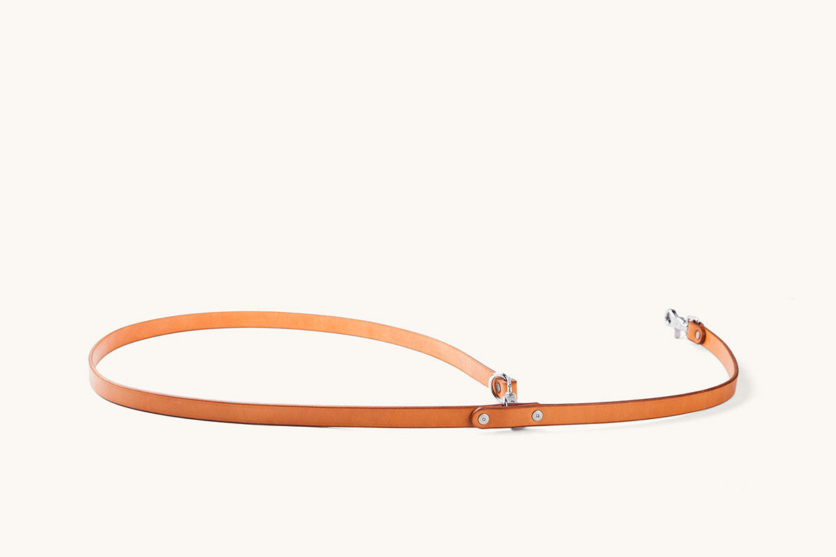 Saddle Tan leather convertible canine lead with silver-toned hardware, laid out on a light background.