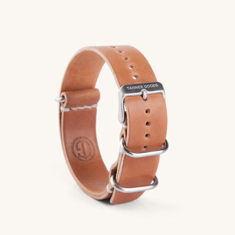 Cordovan leather NATO watch strap in natural tan by Tanner Goods, featuring silver-tone hardware and white stitching, side view.
